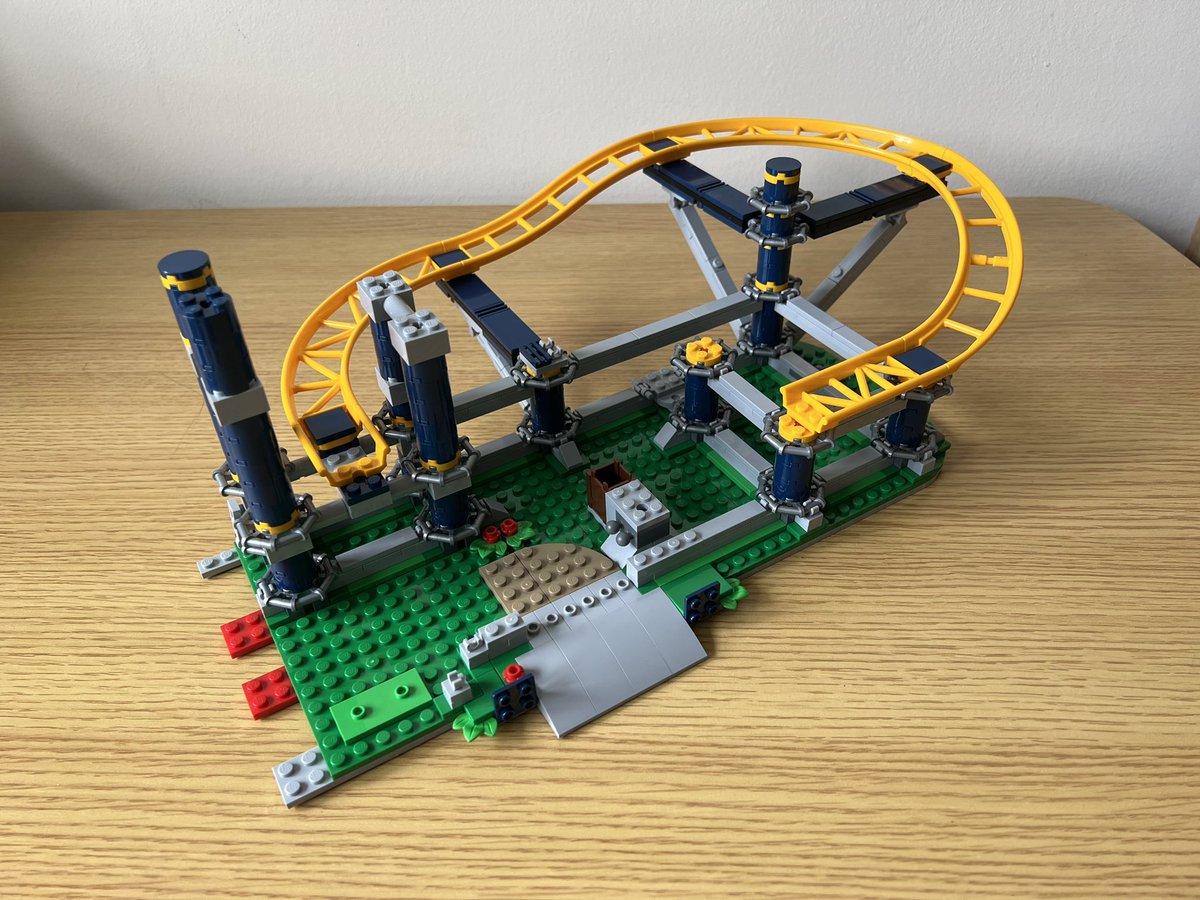 A partially built lego roller coaster with a section of track that does a 270 degree turn while going down a slope